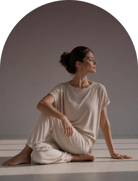 Una donna seduta su un pavimento che esegue una posizione dell'Hatha Yoga